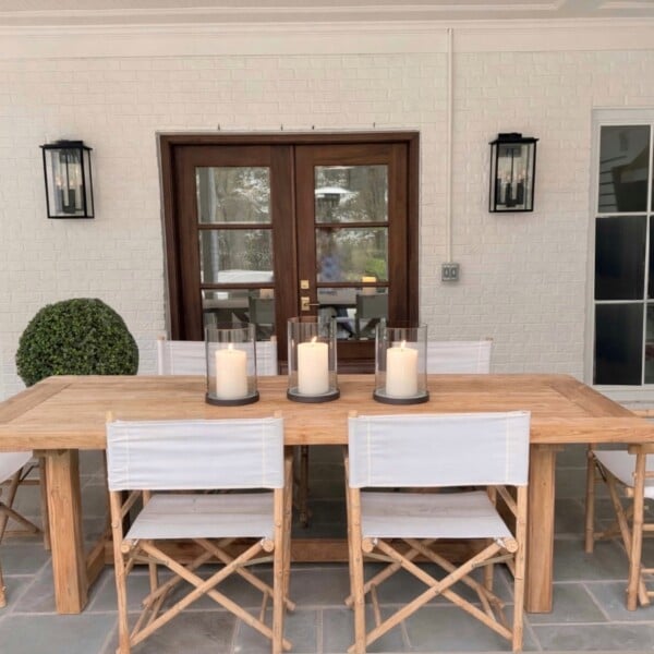 Six Yohana folding director chairs around a teak dining table on a covered patio